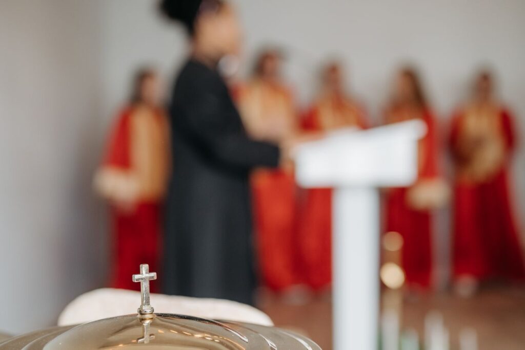 A blurred choir and priest with a focused cross in a church setting, creating a spiritual atmosphere.